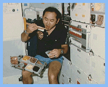 Astronuat Onizuka enjoying a meal onboard the Space Shuttle, NASA photo.